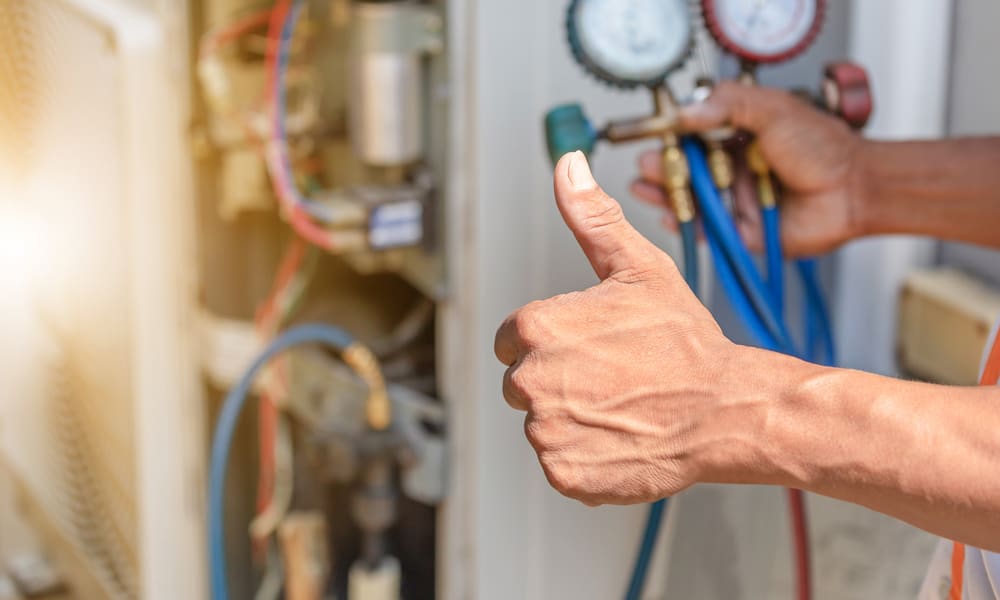 Un technicien en chauffage qui répare une thermopompe